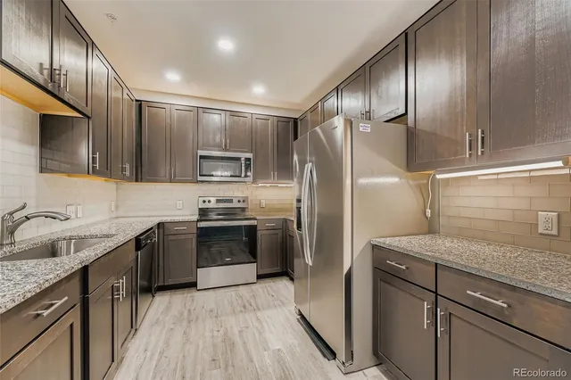 a kitchen with granite countertop stainless steel appliances cabinets a sink and a counter space
