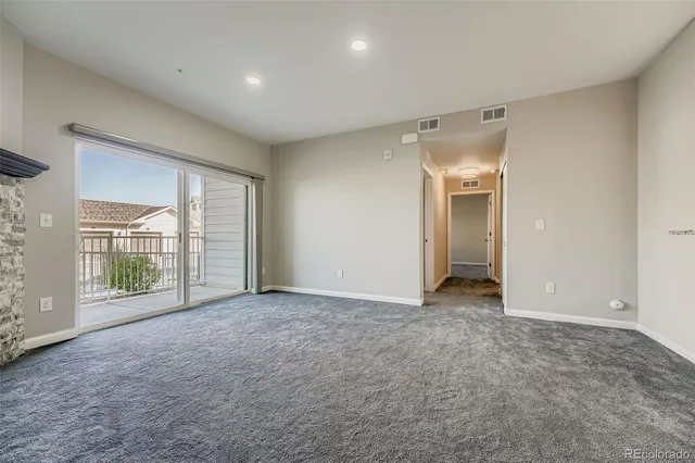 en empty room with windows and chandelier