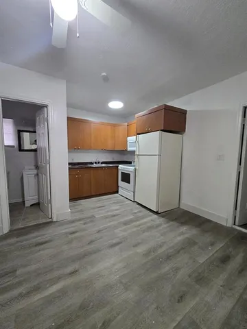 a view of a kitchen with a sink and a refrigerator