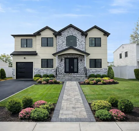 a front view of a house with a yard and garage