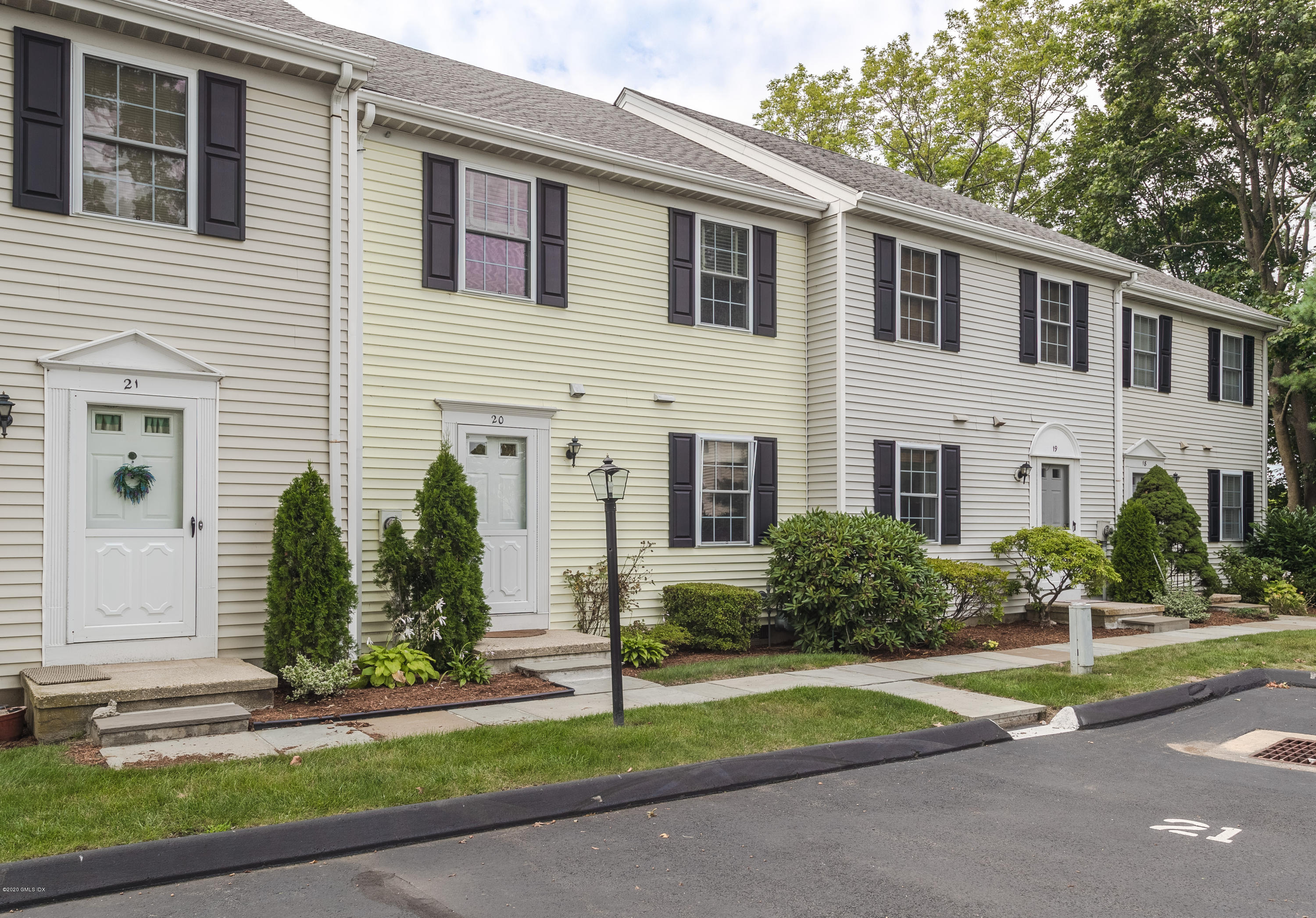 33 Talbot Lane, Unit 20 Greenwich, CT 06830 - Photo 1 of 20 a view of a house with small yard plants and a large tree