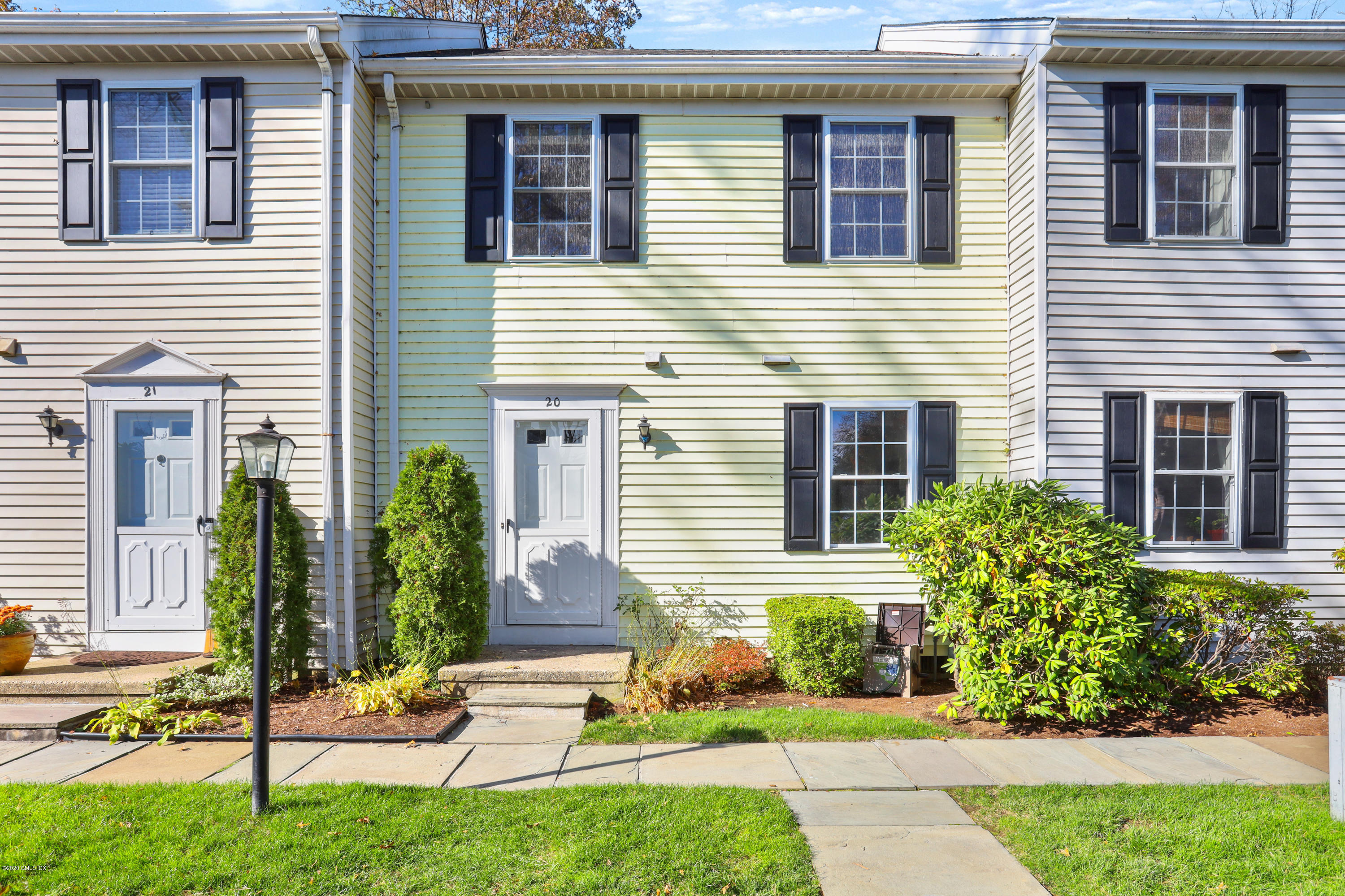33 Talbot Lane, Unit 20 Greenwich, CT 06830 - Photo 2 of 20 a view of a house with a small yard and plants