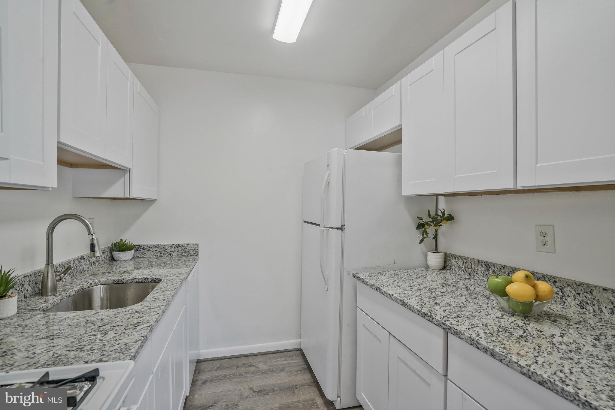 2754 Hollywood Road, Unit 301 Falls Church, VA 22043 - Photo 20 of 35 a kitchen with granite countertop a sink a stove and cabinets