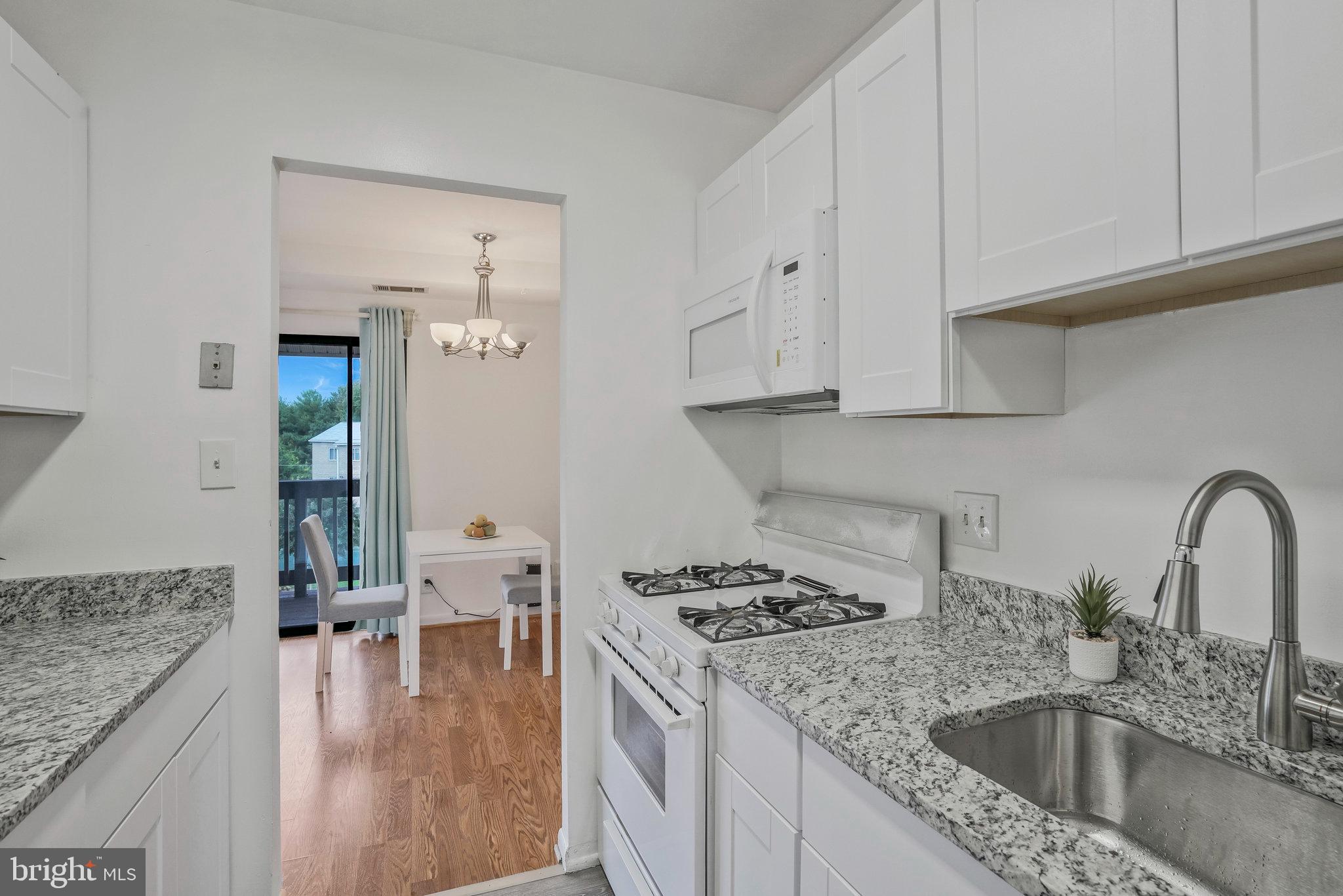 2754 Hollywood Road, Unit 301 Falls Church, VA 22043 - Photo 21 of 35 a kitchen with granite countertop a sink a stove and cabinets
