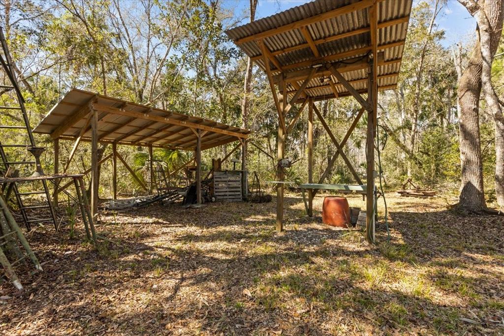 86 Southwest Turtle Pass Road Chiefland, FL 32626 - Photo 23 of 37 a view of a backyard with table and chairs under an umbrella