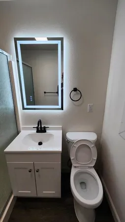 a bathroom with a toilet sink and mirror