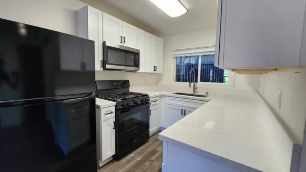 a kitchen with stainless steel appliances a refrigerator stove and microwave