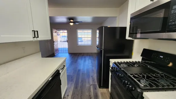 a kitchen with stainless steel appliances a stove a refrigerator and a microwave