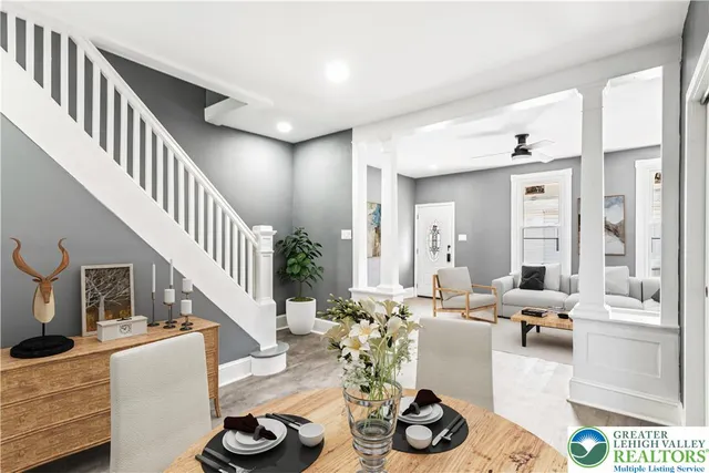 a living room with furniture kitchen view and a large window