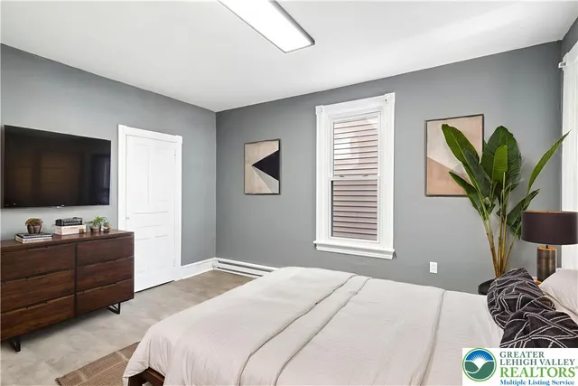 a bedroom with a bed and a flat screen tv