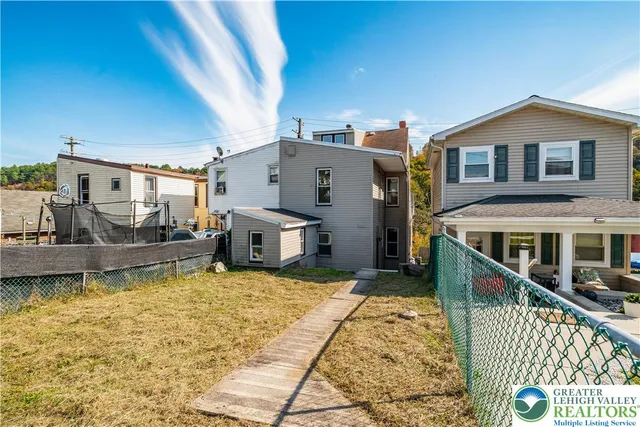 a view of a house with pool and sitting area