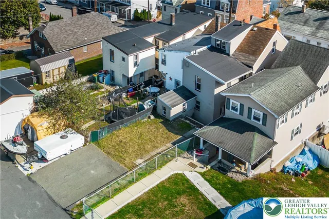 an aerial view of multiple houses with a yard