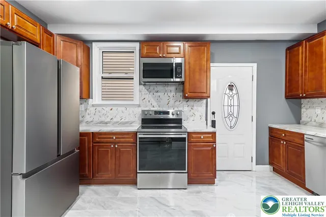 a kitchen with stainless steel appliances granite countertop a stove a refrigerator and a stove top oven