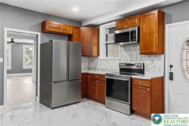a kitchen with stainless steel appliances granite countertop a refrigerator and a stove top oven