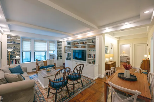a living room with furniture a flat screen tv and a large window