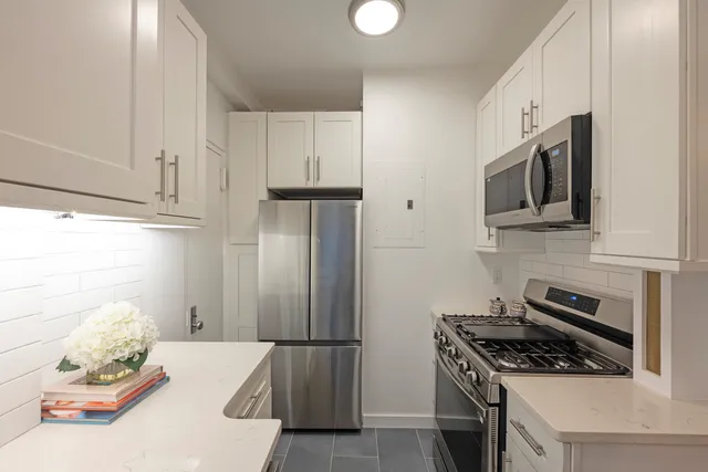 a kitchen with stainless steel appliances granite countertop a refrigerator stove and microwave