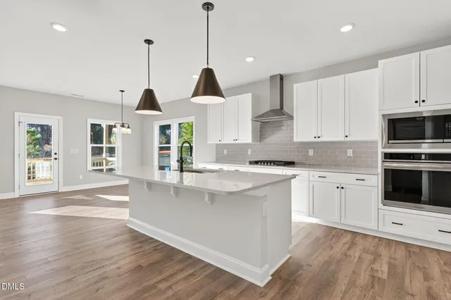 a open kitchen with granite countertop white cabinets and white appliances