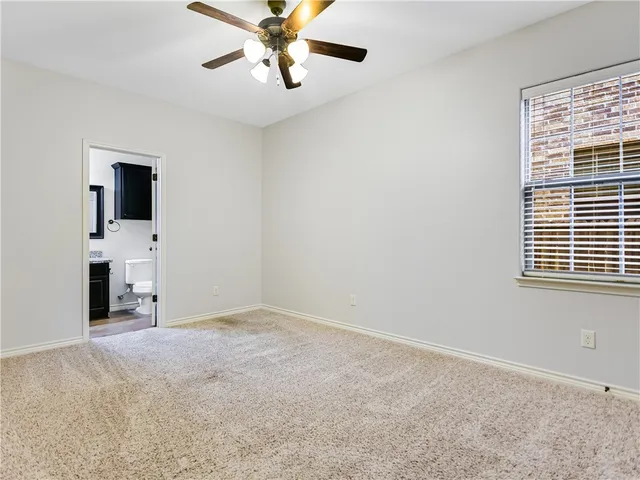 a view of empty room with a ceiling fan and window