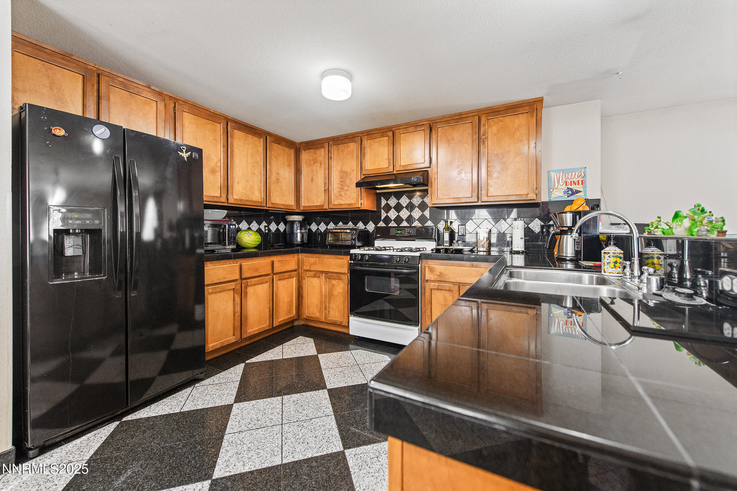 532 Yellow Jacket Road Dayton, NV 89403 - Photo 10 of 18 a kitchen with stainless steel appliances kitchen island granite countertop a refrigerator a stove and a sink with wooden floor