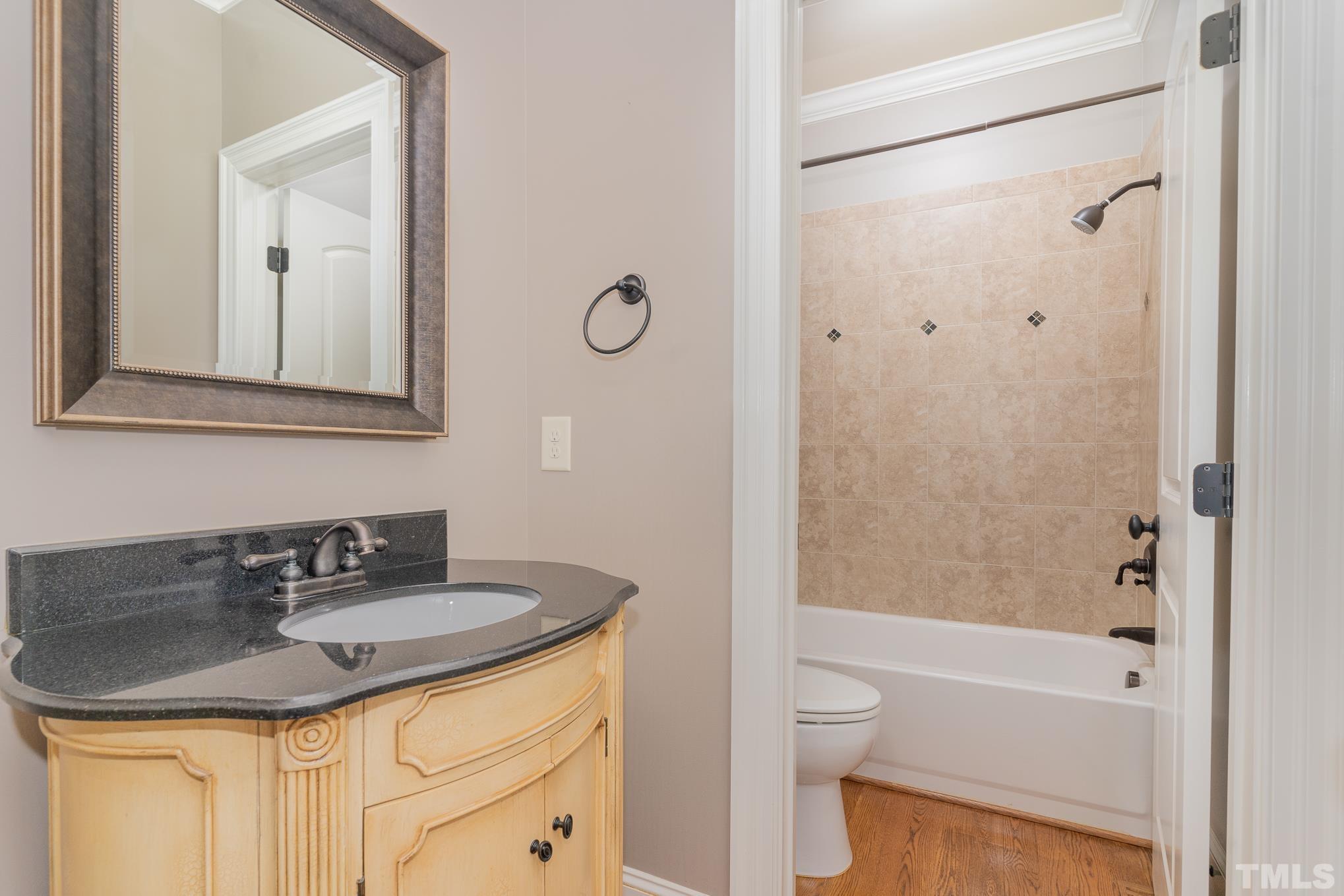 5004 Greyhawk Place Apex, NC 27539 - Photo 11 of 36 a bathroom with a granite countertop sink toilet and shower