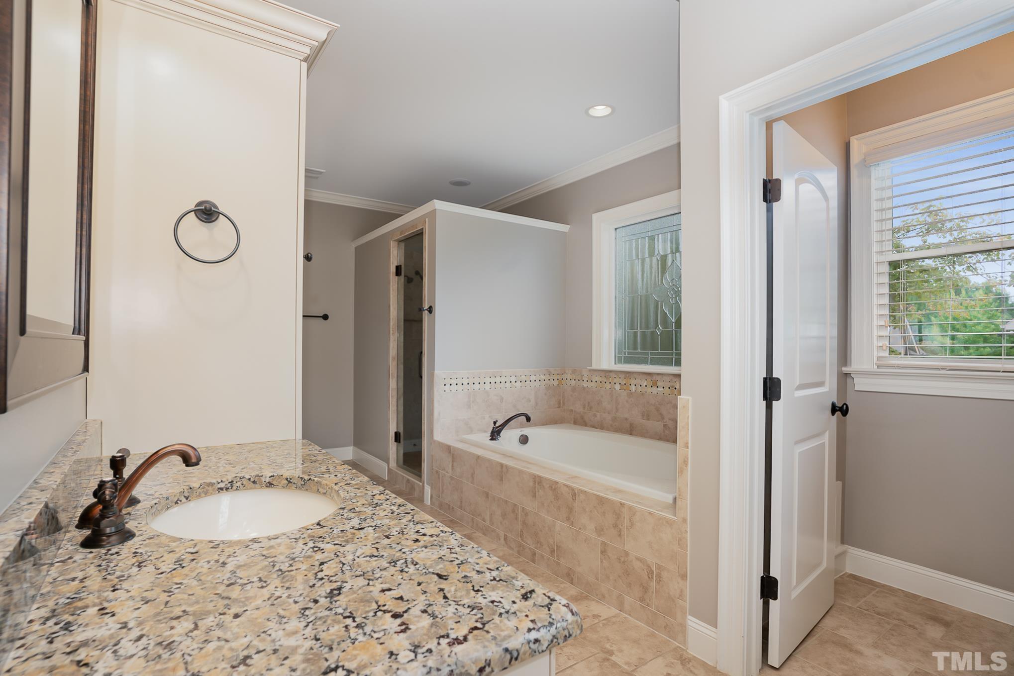 5004 Greyhawk Place Apex, NC 27539 - Photo 15 of 36 a bathroom with a tub sink and mirror