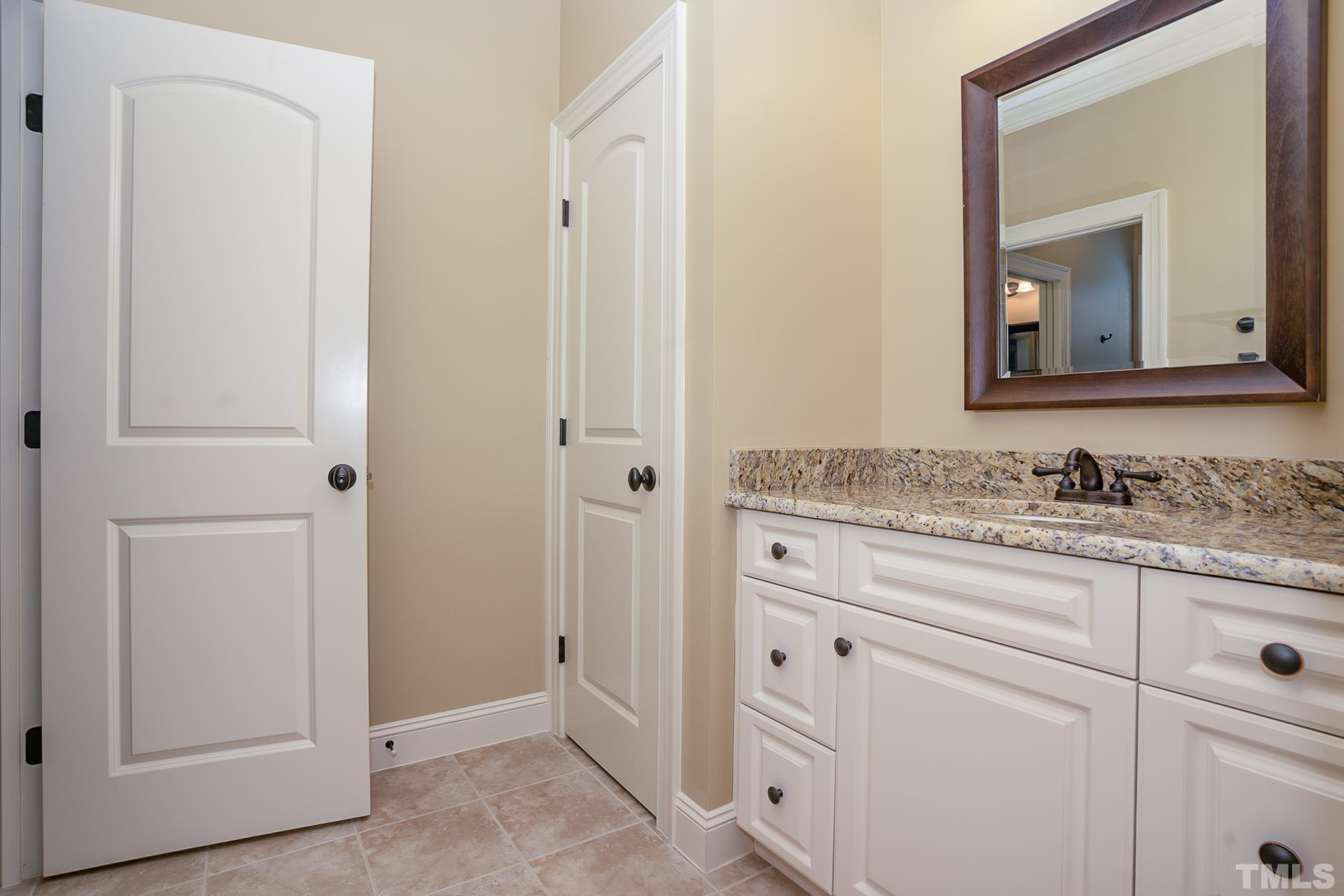 5004 Greyhawk Place Apex, NC 27539 - Photo 17 of 36 a bathroom with a granite countertop sink and a mirror