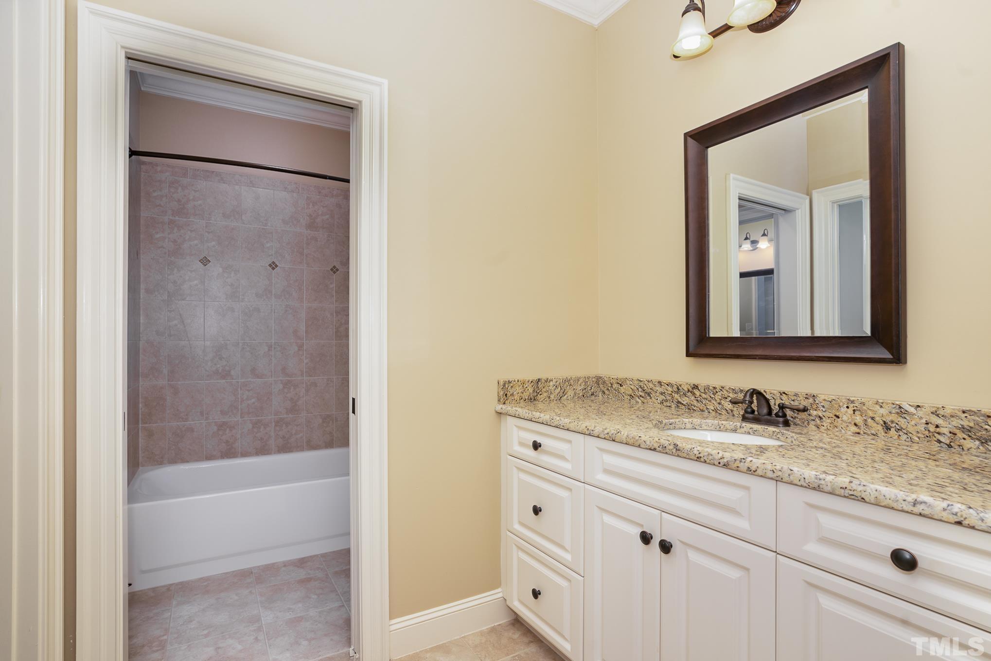 5004 Greyhawk Place Apex, NC 27539 - Photo 19 of 36 a bathroom with a granite countertop sink mirror and vanity