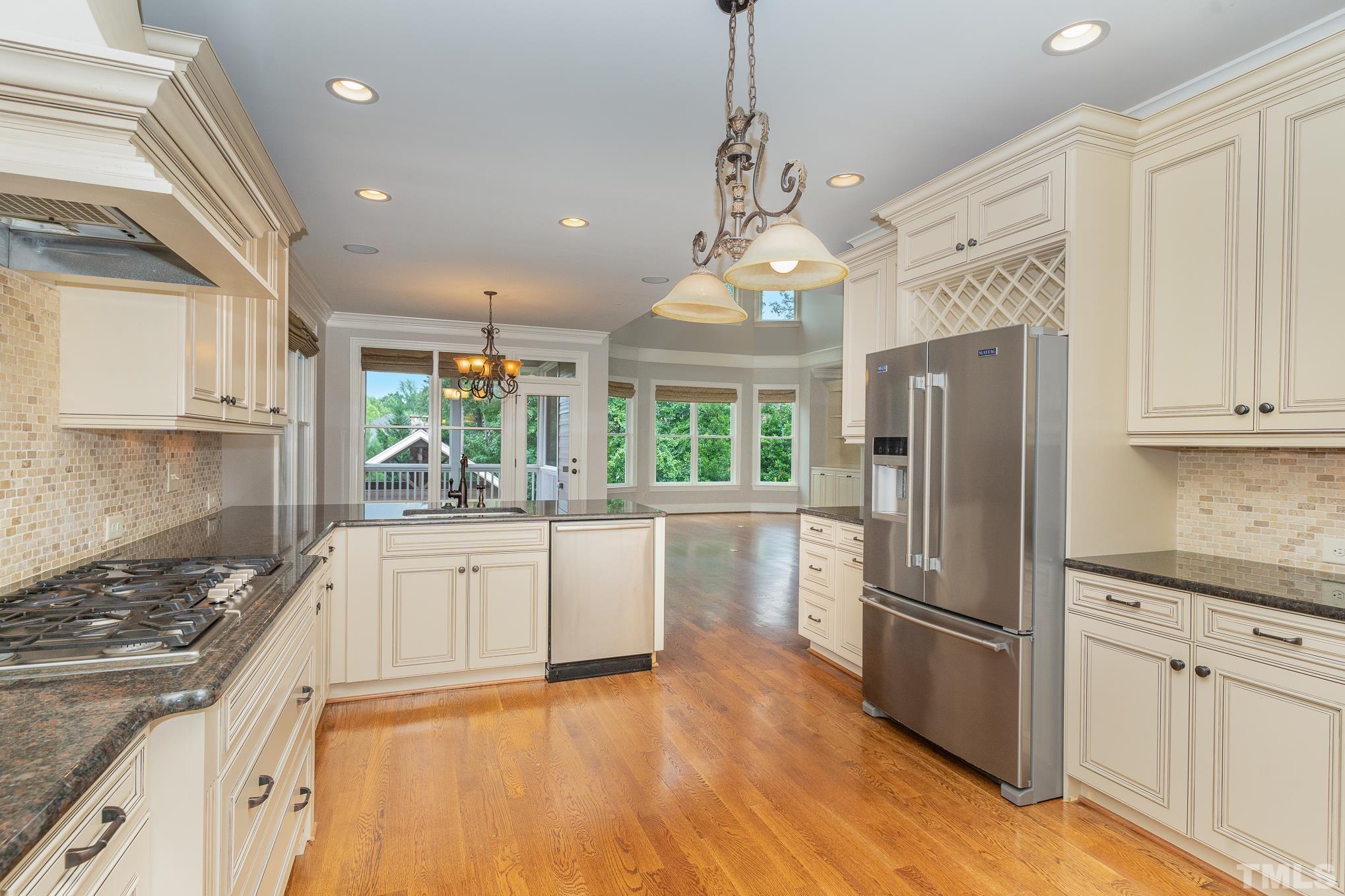 5004 Greyhawk Place Apex, NC 27539 - Photo 8 of 36 a kitchen with stainless steel appliances granite countertop a refrigerator a oven a stove and white cabinets with wooden floor