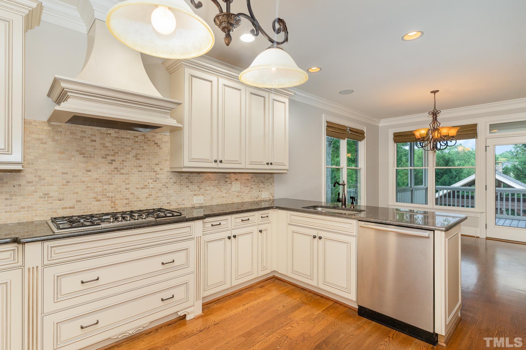 5004 Greyhawk Place Apex, NC 27539 - Photo 9 of 36 a kitchen with granite countertop white cabinets and white appliances