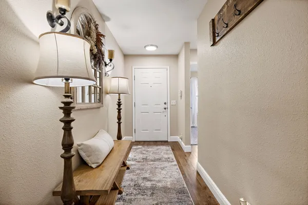 a view of a hallway with wooden floor and staircase