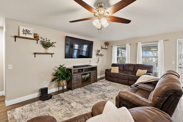 a living room with furniture ceiling fan and a flat screen tv