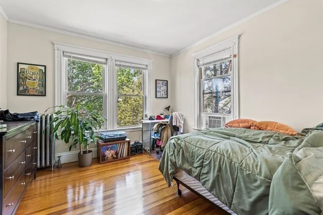a bed sitting in a bedroom next to a window with a flat screen tv