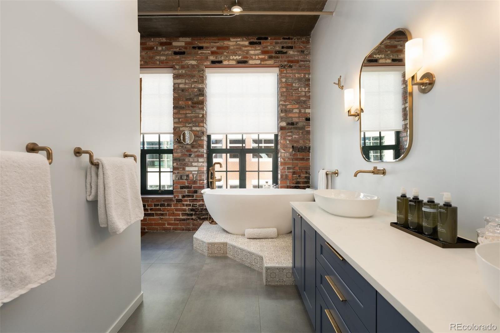 1801 Wynkoop Street, Unit 603 Denver, CO 80202 - Photo 13 of 40 a en suite bathroom with a bathtub sink and mirror