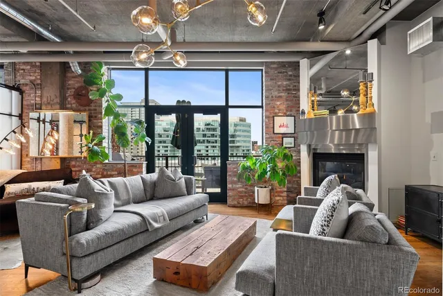 a living room with furniture a potted plant and a fireplace