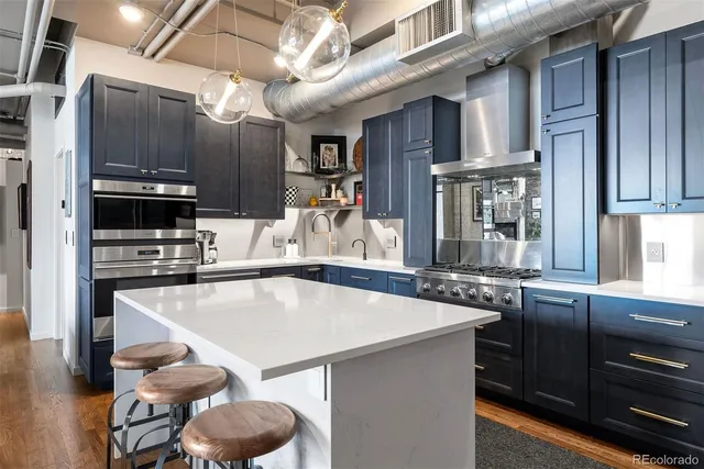 a kitchen with stainless steel appliances granite countertop a sink a stove and a refrigerator