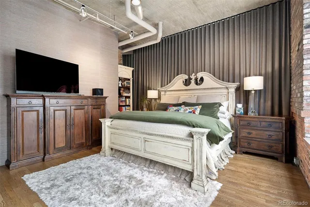 a bedroom with a bed and a flat screen tv