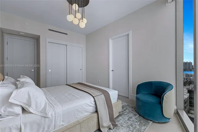 a bedroom with a bed lamp and a chandelier