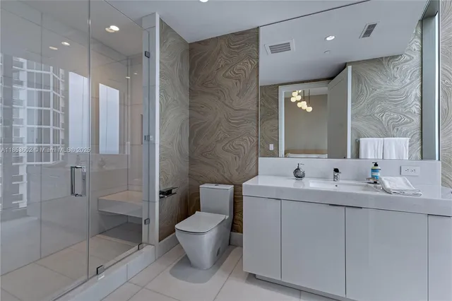 a bathroom with a double vanity sink toilet and shower
