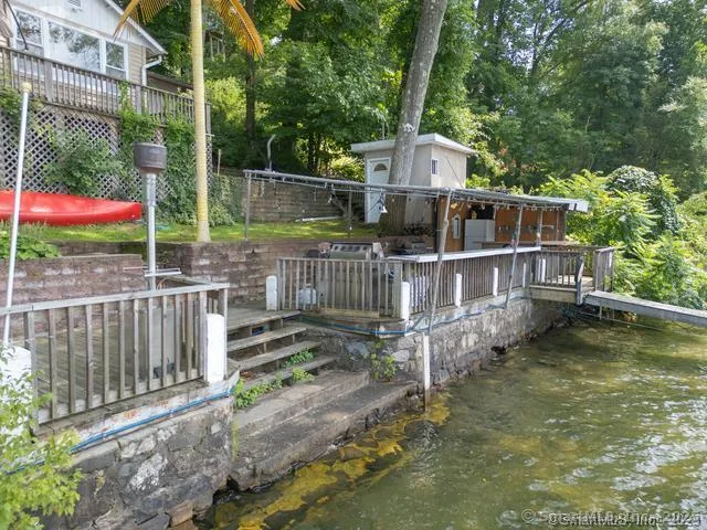 a backyard of a house with table and chairs potted plants