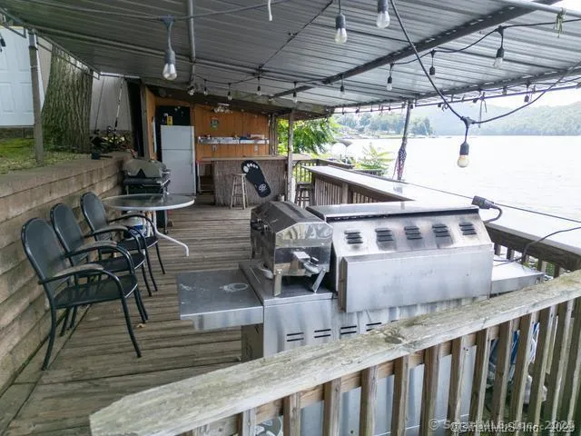 a view of a swimming pool with lawn chairs and a large tree