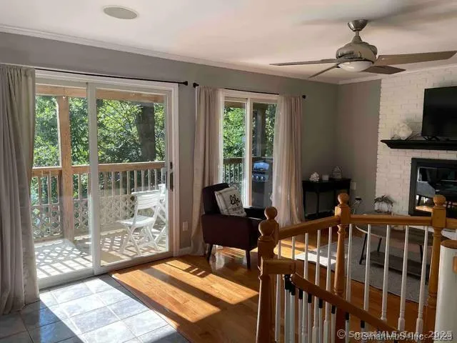 a living room with furniture a flat screen tv and a floor to ceiling window