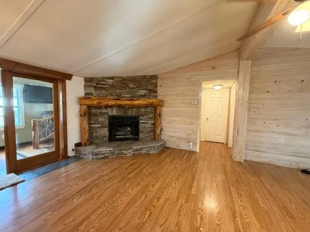 an empty room with wooden floor and fireplace