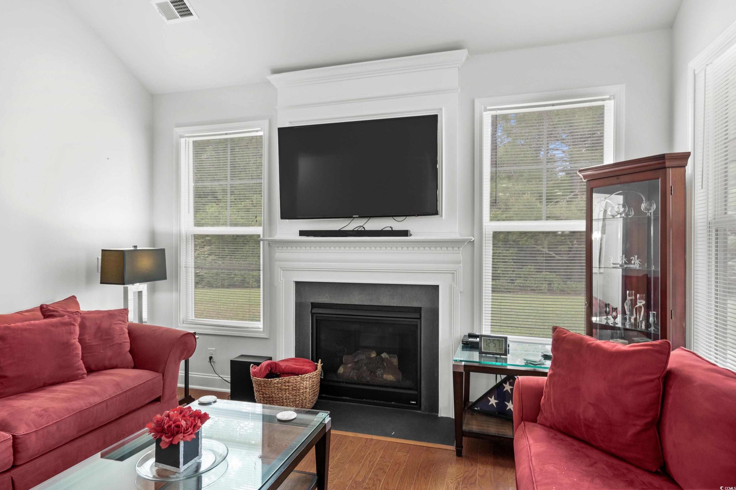 4246 Livorn Loop Myrtle Beach, SC 29579 - Photo 11 of 40 Living area with vaulted ceiling, a large fireplace, visible vents, and wood finished floors