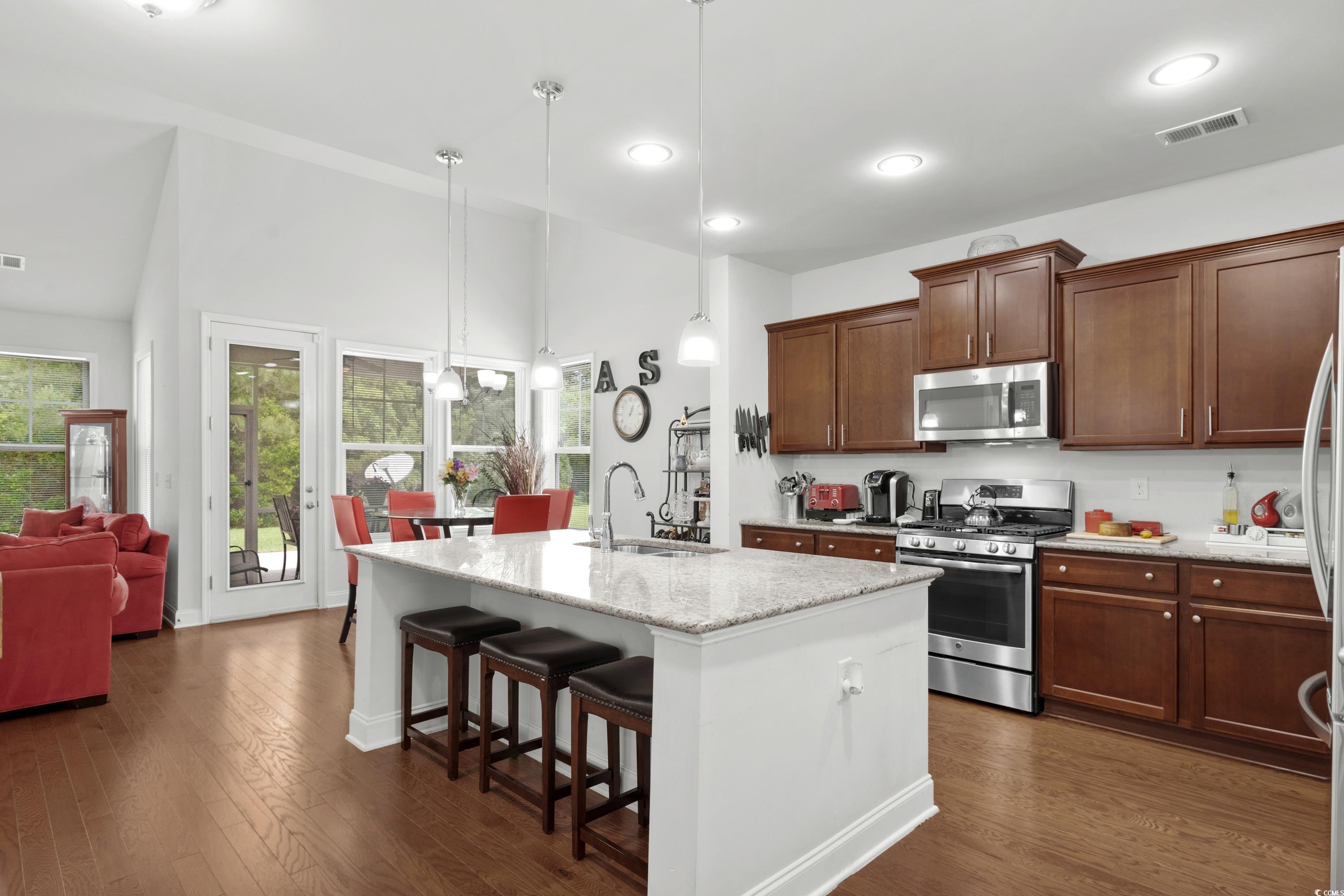 4246 Livorn Loop Myrtle Beach, SC 29579 - Photo 12 of 40 Kitchen featuring a breakfast bar, a sink, high vaulted ceiling, stainless steel appliances, and an island with sink