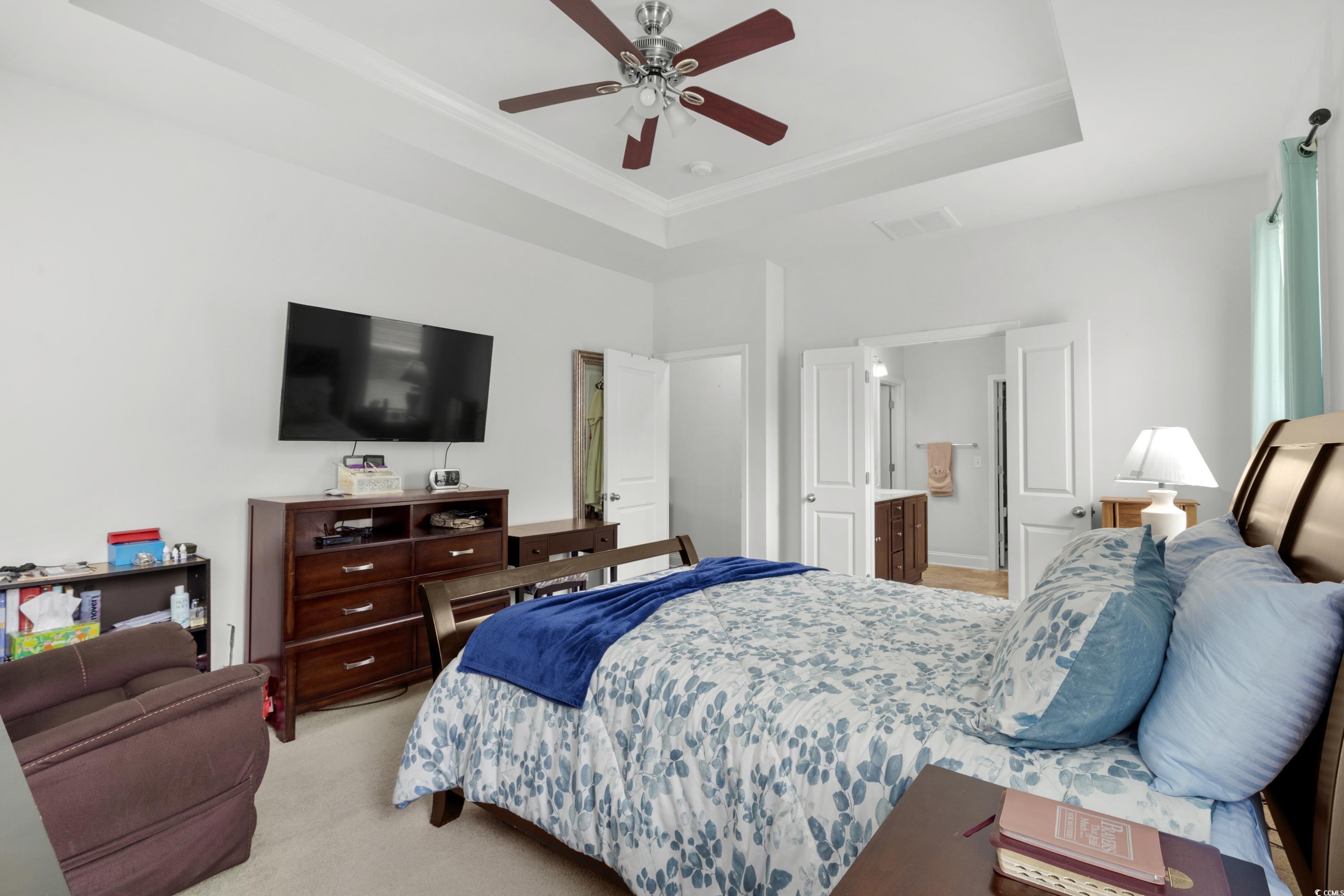 4246 Livorn Loop Myrtle Beach, SC 29579 - Photo 17 of 40 Bedroom featuring a tray ceiling, ceiling fan, visible vents, crown molding, and light carpet