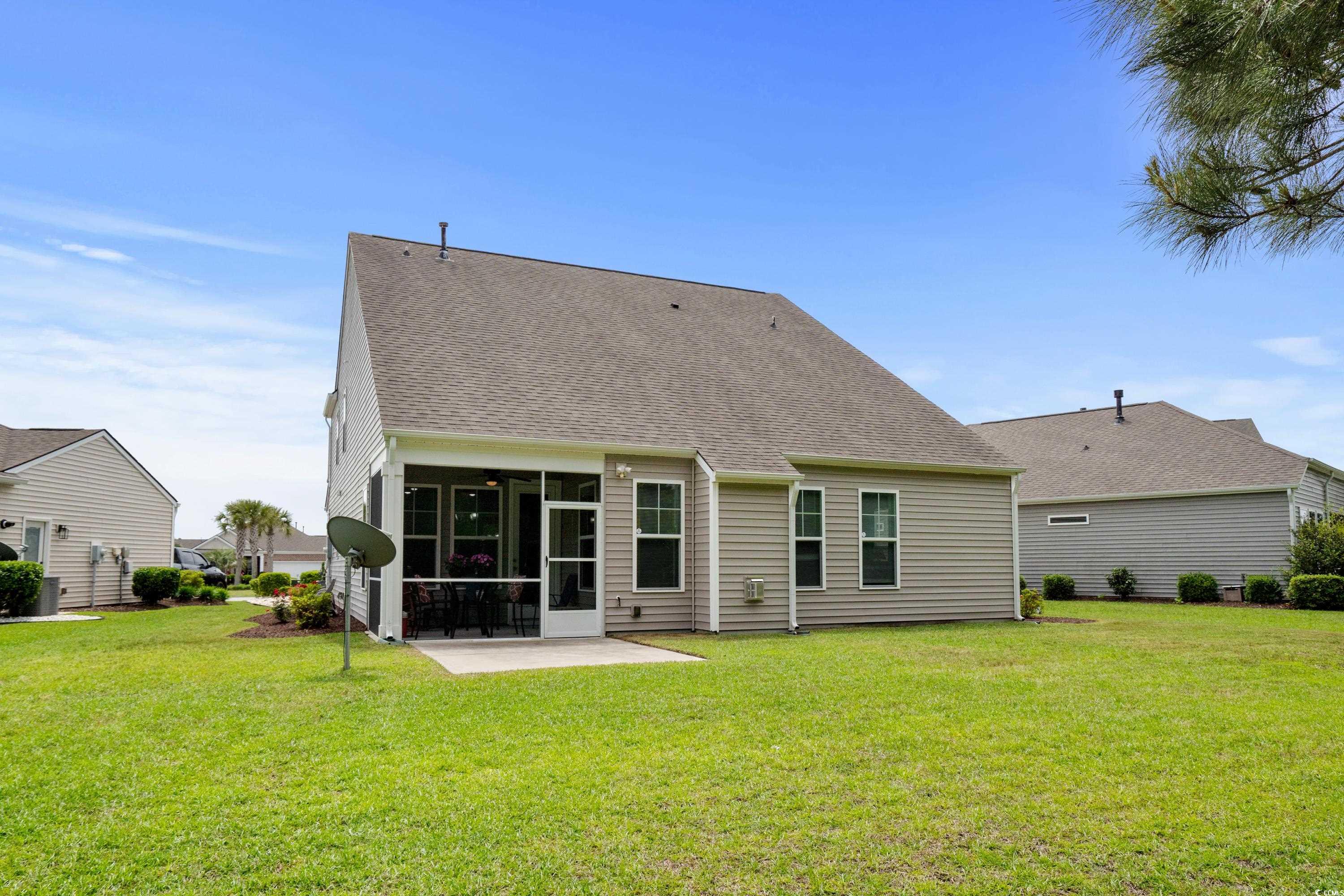 4246 Livorn Loop Myrtle Beach, SC 29579 - Photo 31 of 40 Back of property with a lawn, a ceiling fan, a patio, a sunroom, and roof with shingles