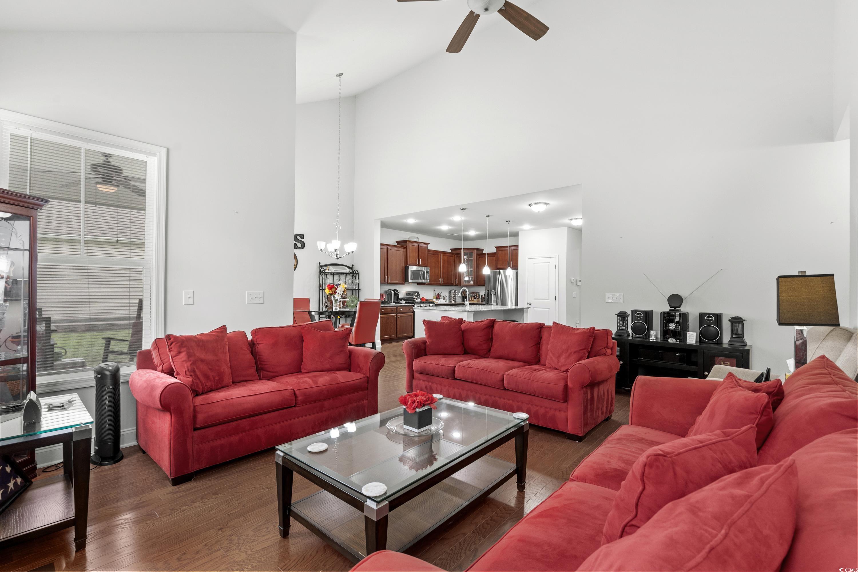 4246 Livorn Loop Myrtle Beach, SC 29579 - Photo 9 of 40 Living room with wood finished floors, high vaulted ceiling, and ceiling fan with notable chandelier