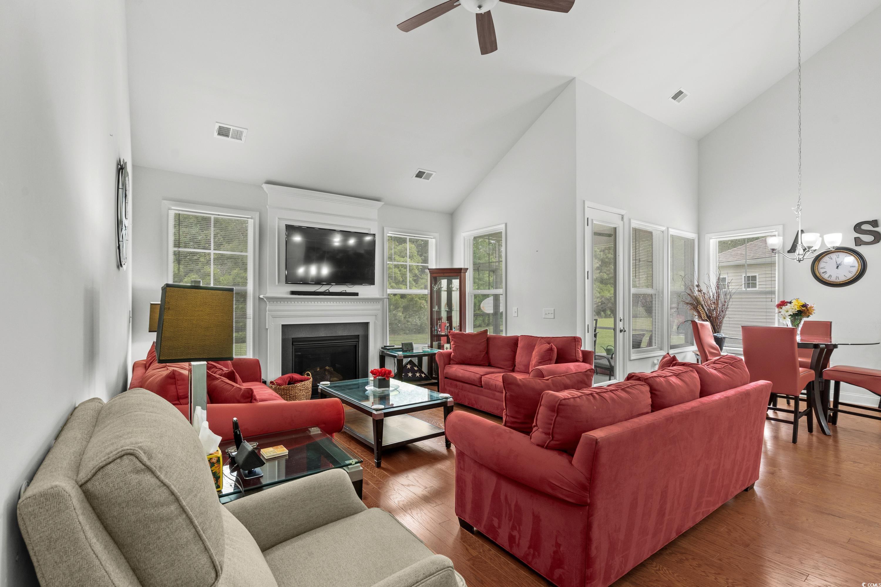 4246 Livorn Loop Myrtle Beach, SC 29579 - Photo 10 of 40 Living room with visible vents, wood finished floors, ceiling fan with notable chandelier, and high vaulted ceiling