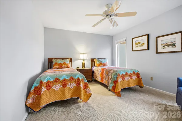 a bedroom with two beds and a chandelier