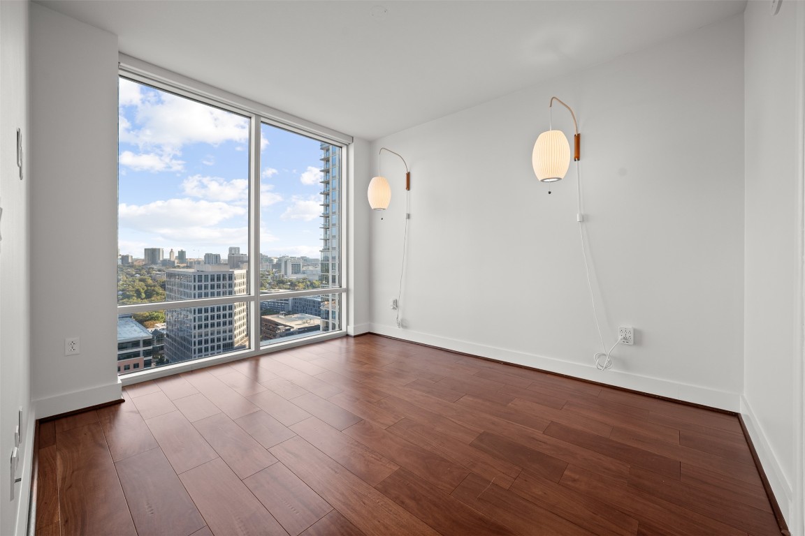 300 Bowie Street, Unit 2405 Austin, TX 78703 - Photo 16 of 39 an empty room with wooden floor and windows